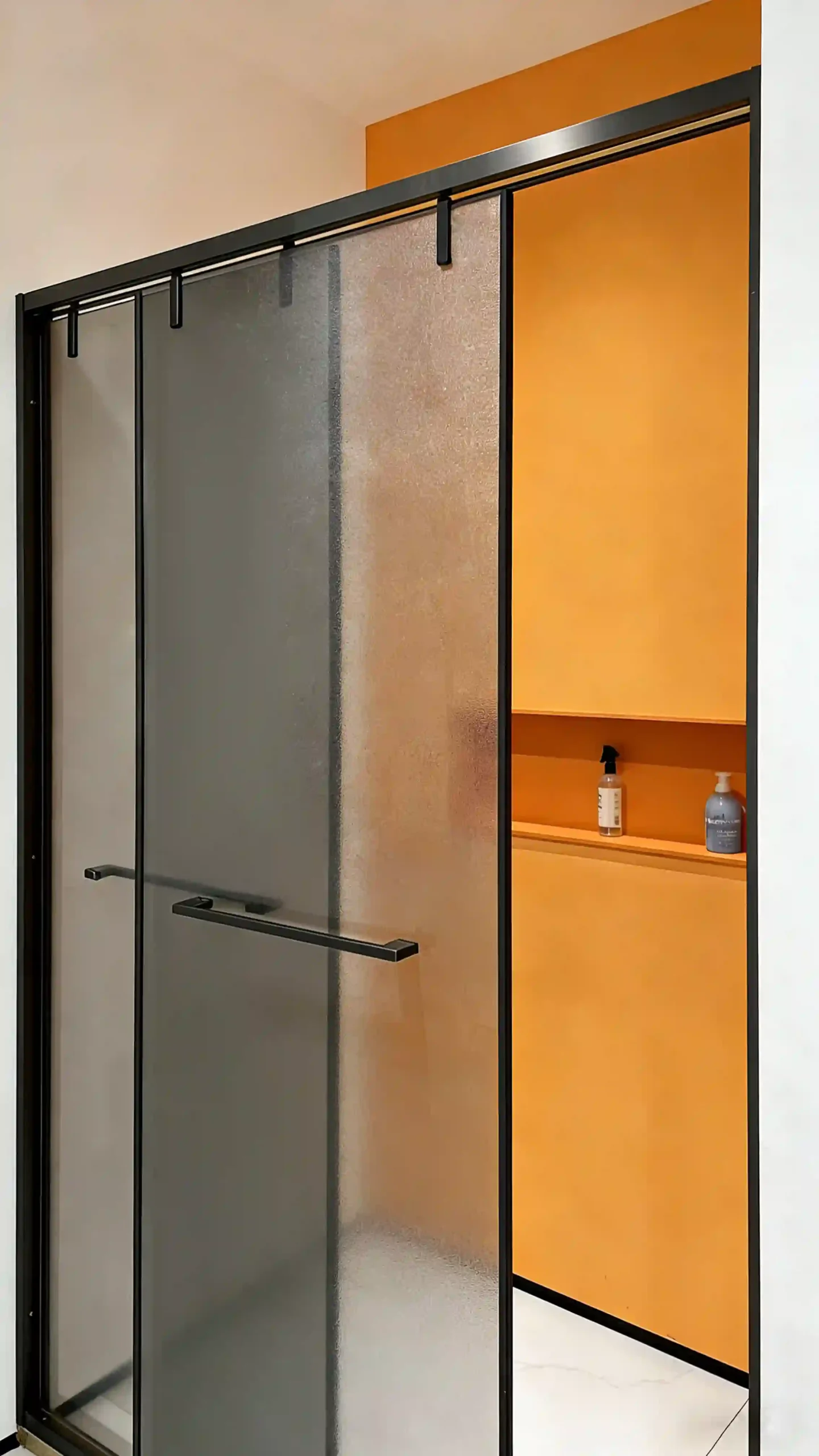 Ergonomic stainless-steel handle and hinge system on PS16602 matte black sliding shower door with frosted glass and integrated towel bar. Select 79 more words to run Humanizer.