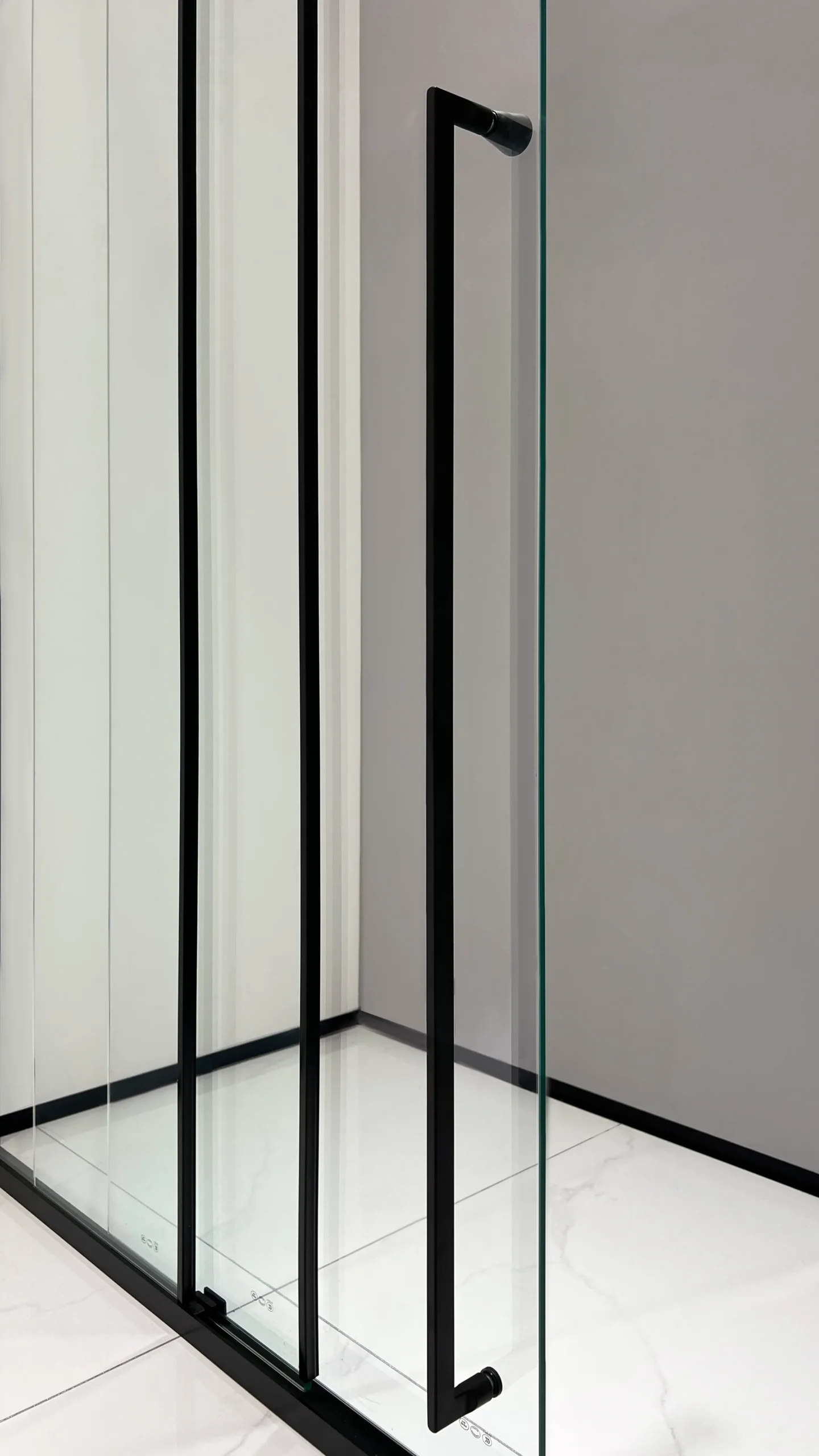 Matte black sliding shower door with smoked glass featuring a long 1-meter handle for comfortable, accessible two-hand support. Select 80 more words to run Humanizer.