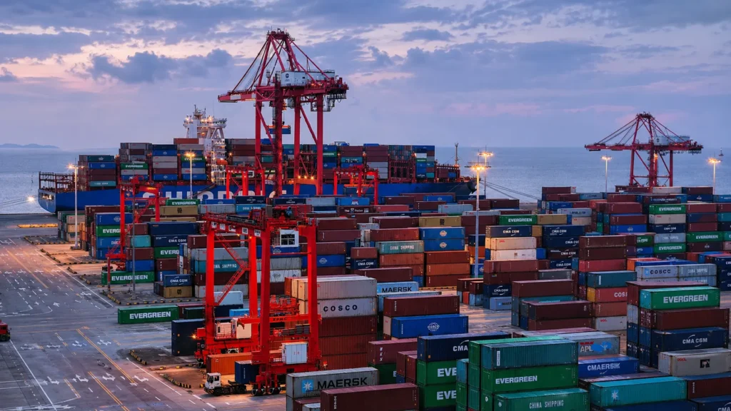Busy container port at dusk, representing global logistics and landed cost for bulk hotel vanity exports from China.