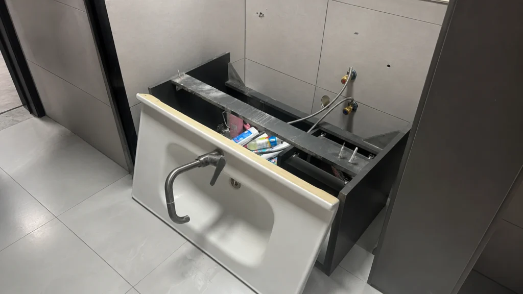 Detached floating vanity sink showing wall support and plumbing issues, highlighting apartment project installation risks.