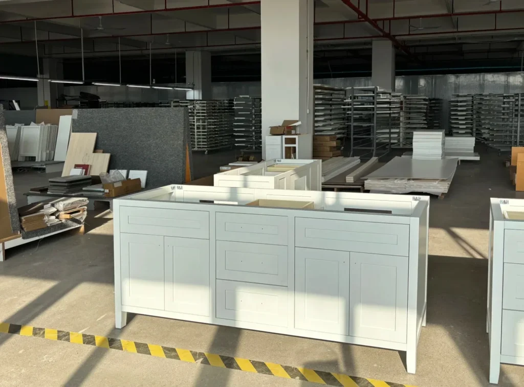 Wide white Shaker vanity base in a factory, showcasing long-term supply and part tracking for hotel project phases.
