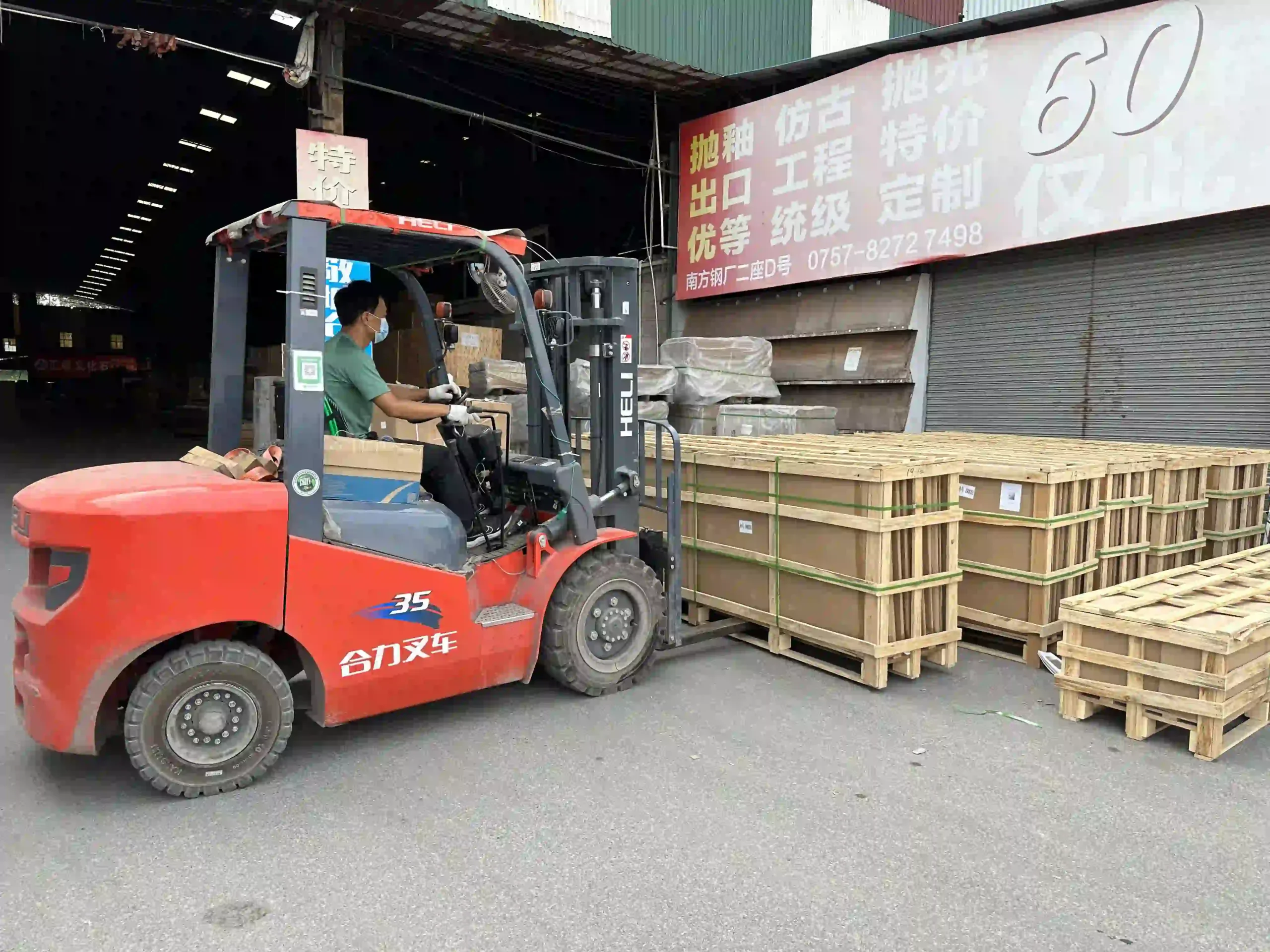 Forklift handling large wooden export shipping crates outside a warehouse during project materials loading